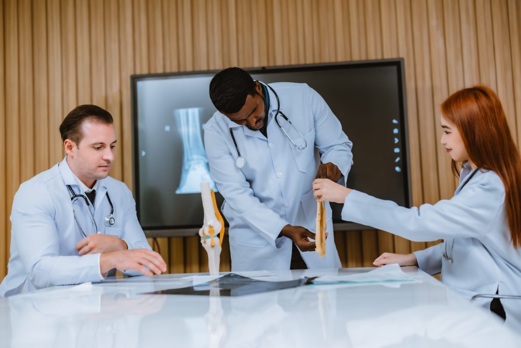 Surgeon and radiologist discuss Pt's ankle's MRI for treatment plan.