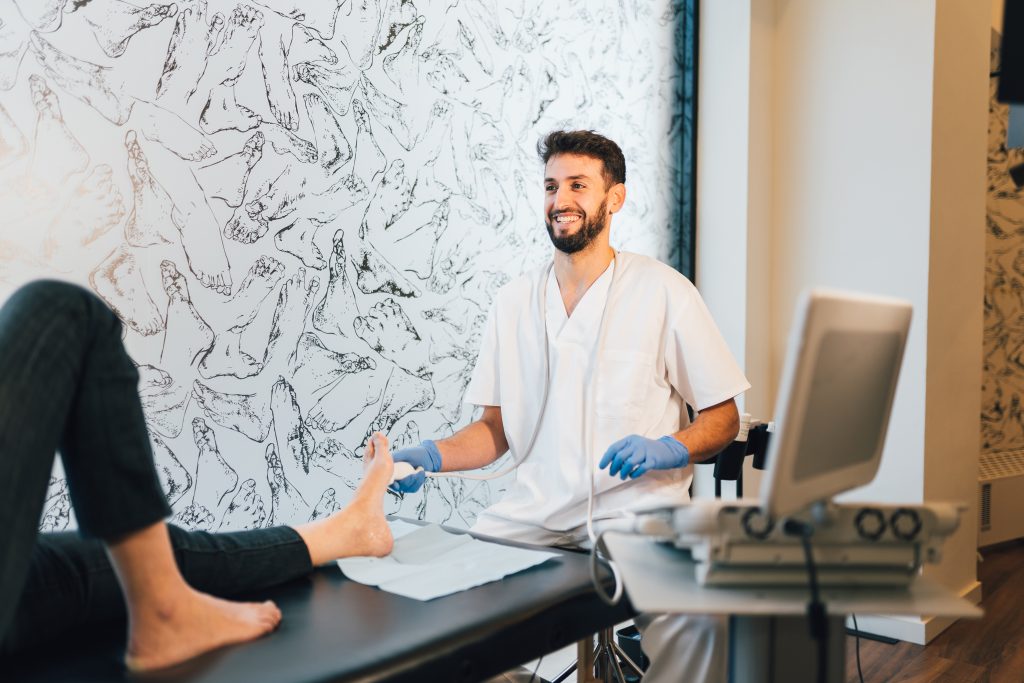Podiatrist doing an ultrasound test to patient's foot